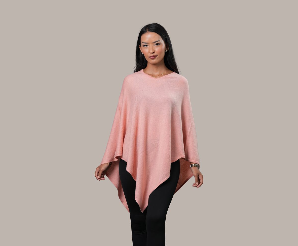 A woman wearing a beautiful soft pink cashmere poncho.